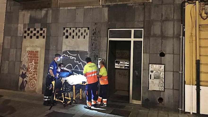 Sanitarios trasladan a la víctima al exterior del edificio de los &quot;okupas&quot;.