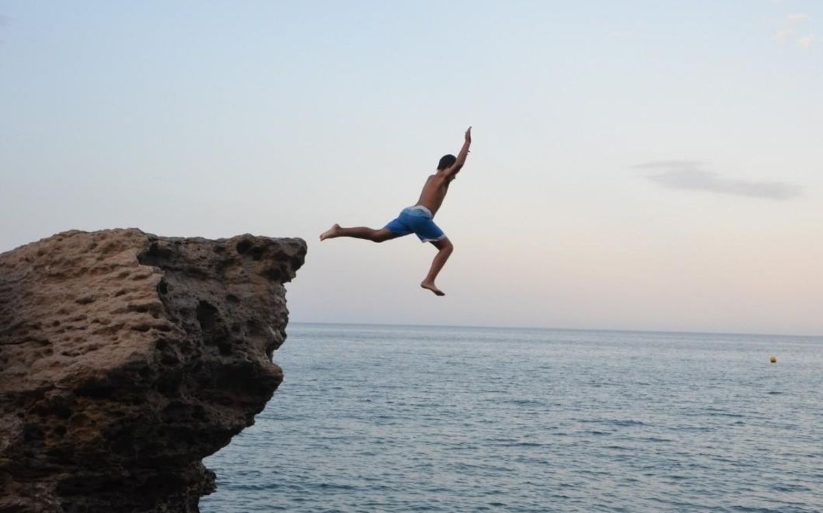 Un chico salta desde una roca de la Costa Brava. Un chico salta desde una roca de la Costa Brava.