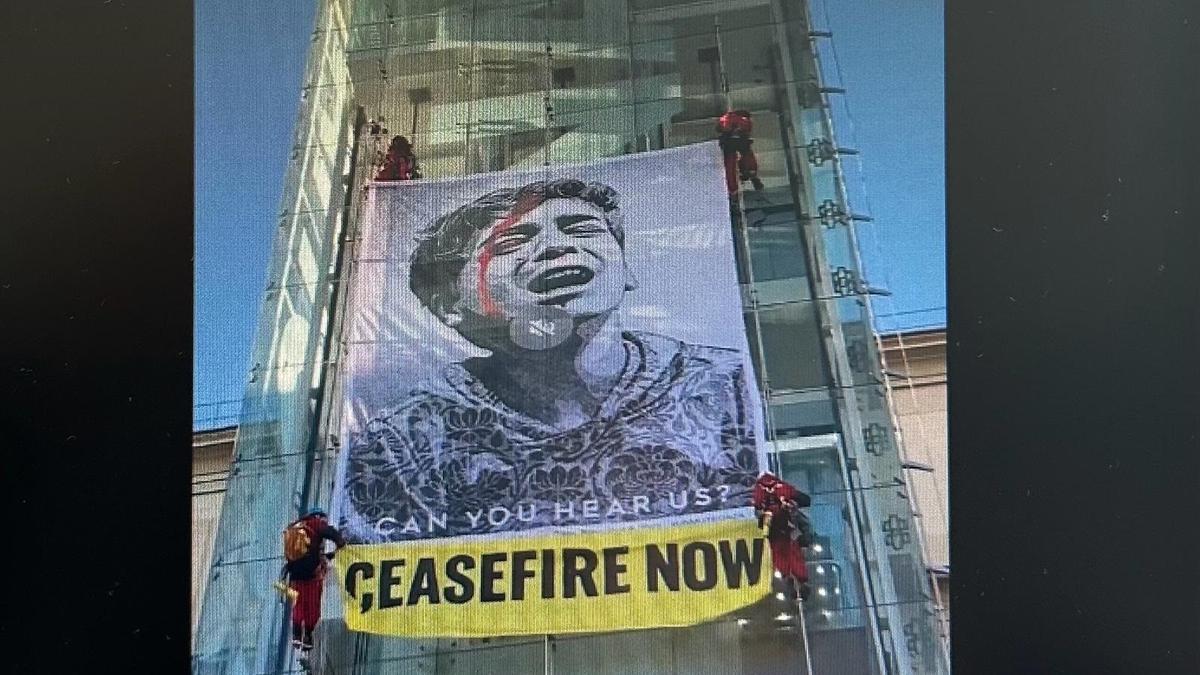 Activistas de Greenpeace cuelgan una pancarta pidiendo un "Alto el fuego ya" en el Museo de Arte Reina Sofía