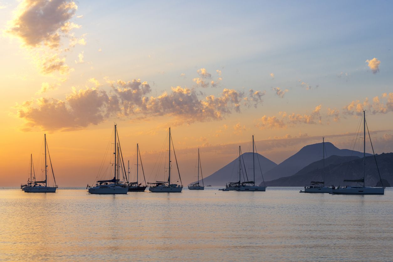 Veleros anclados en la bahía al atardecer, Sicilia, Italia