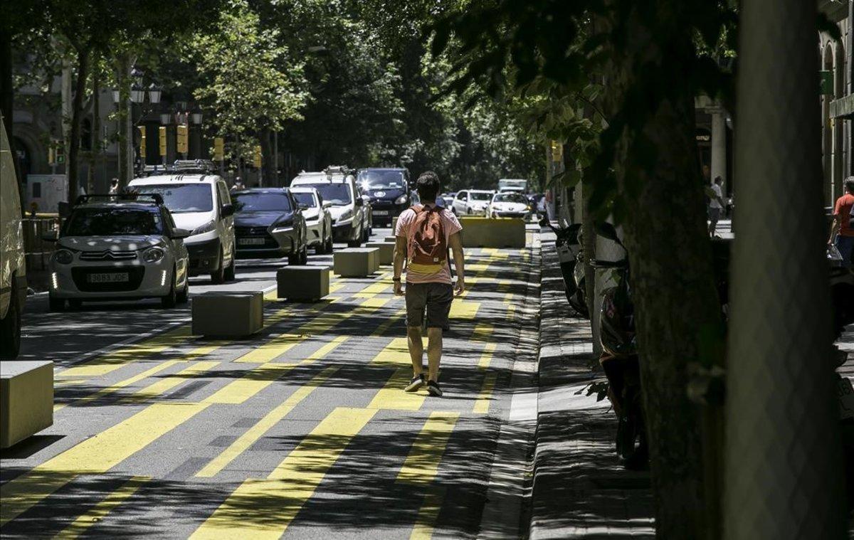 Un hombre pasea por la calle de Consell de Cent a la altura de Pau Claris.