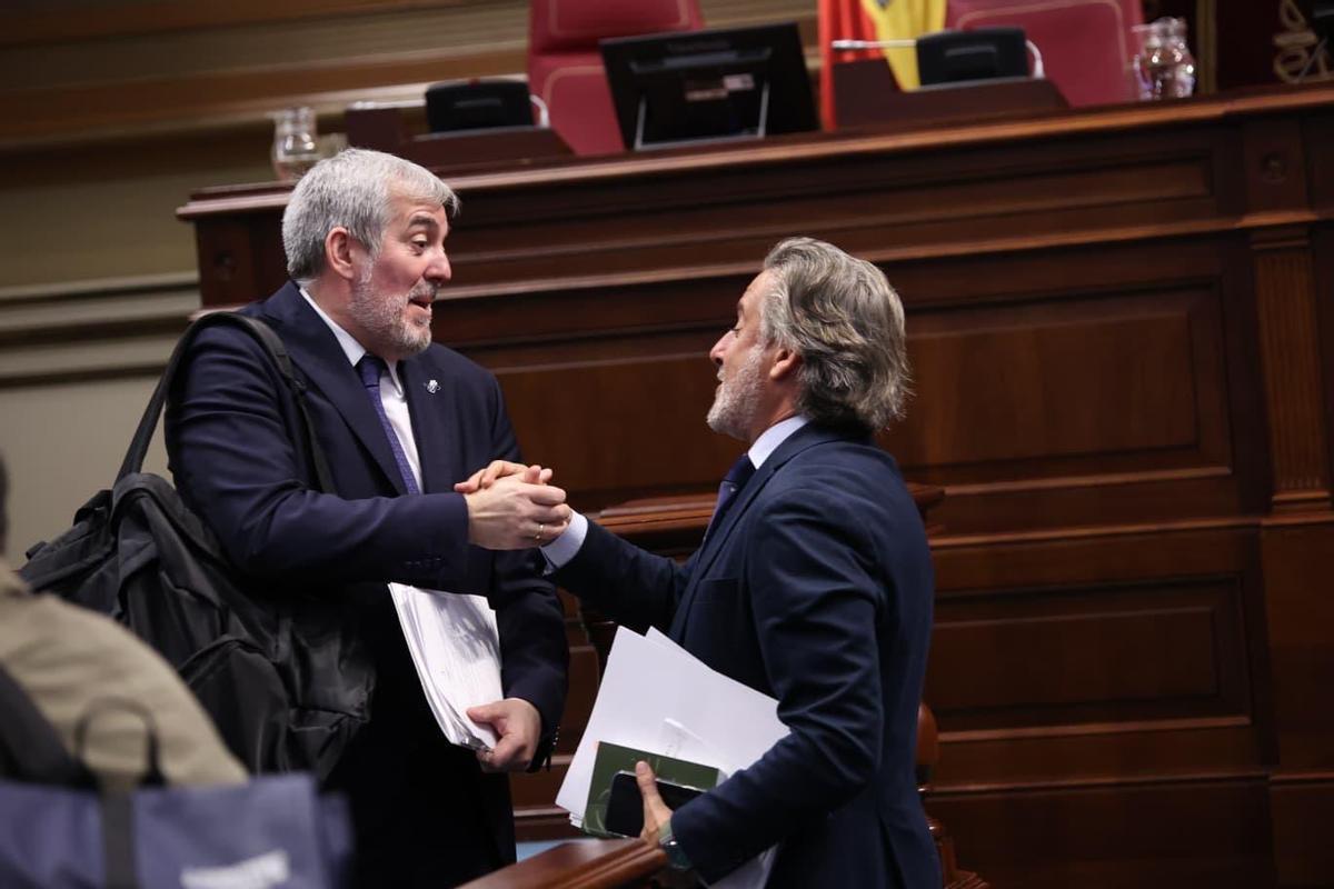 El presidente Fernando Clavijo (i) saluda al socialista Gustavo Matos antes del inicio de la sesión plenaria en el Parlamento.