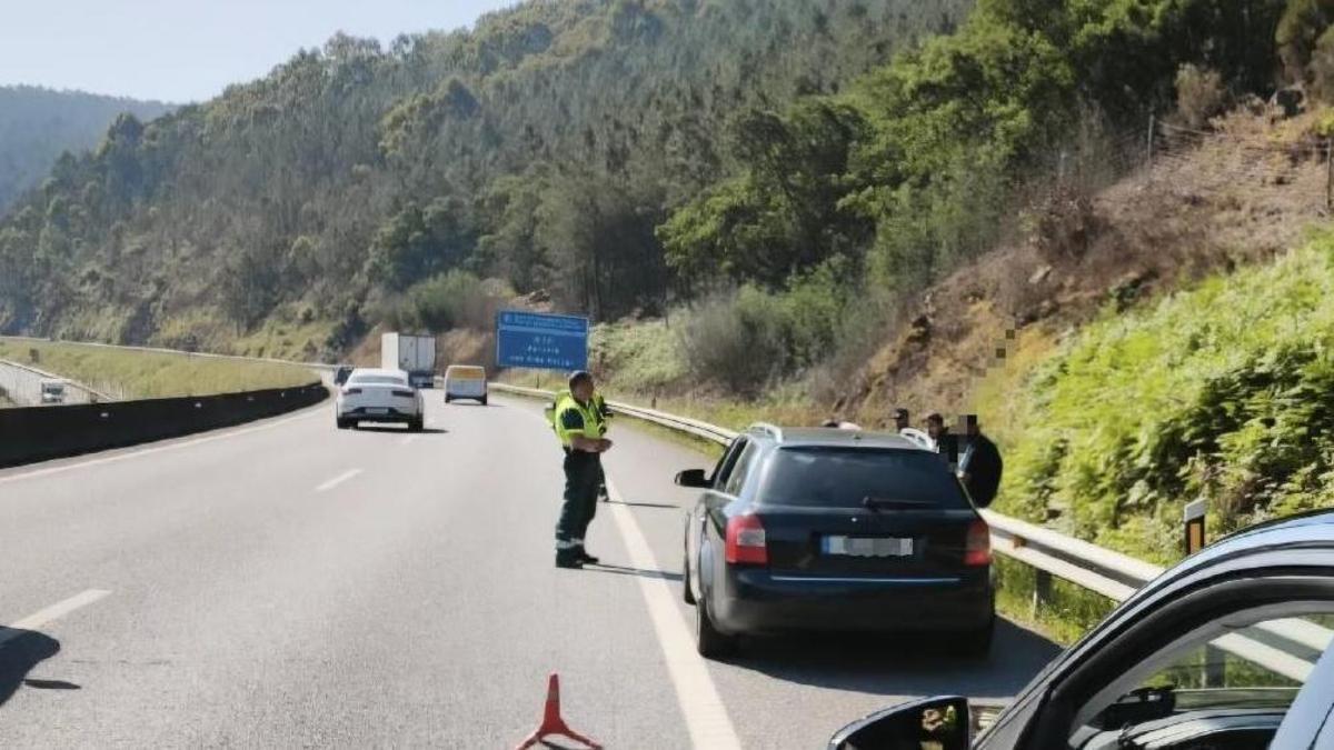 El vehículo interceptado por la Guardia Civil de Tráfico, con los ocupantes en el exterior.