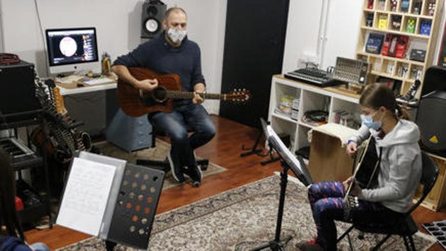 Albert Gilabert, professor de guitarra de l&#039;aula El Traster de Mollerussa, fent classe amb dos alumnes, en la represa de les activitats extraescolars, el 23 de novembre de 2020