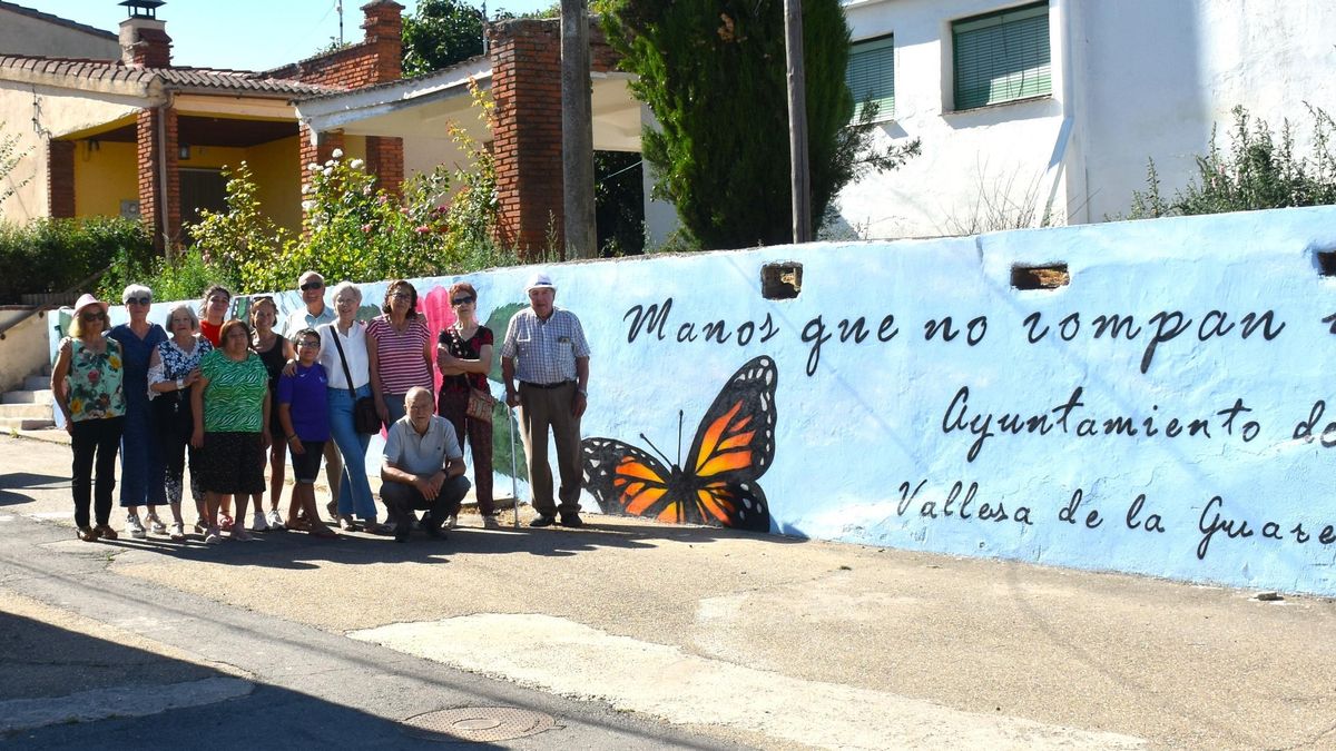 Vecinos de Vallesa junto a la alcaldesa Azucena Hernández y la teniente de alcalde, Rosario Salanova, junto al mural contra la violencia de género pintado en un muro de 28 metros