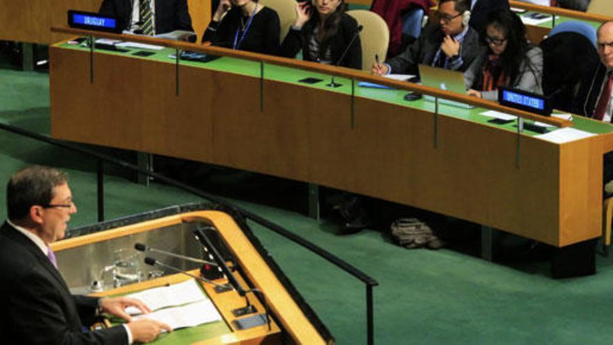 Ronald Godard (d) escucha al secretario cubano (i) en la ONU.