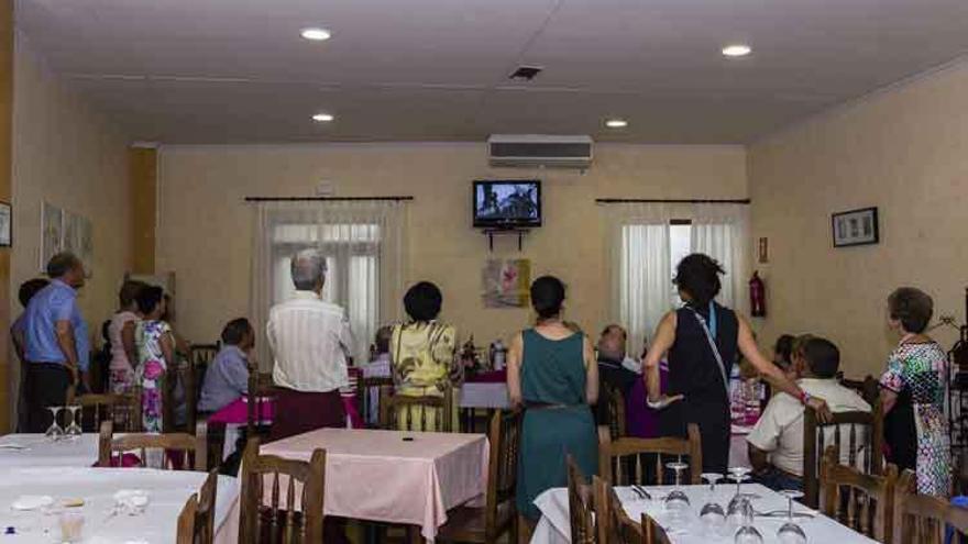 Un grupo de personas sigue un programa de televisión en un restaurante de Tábara.