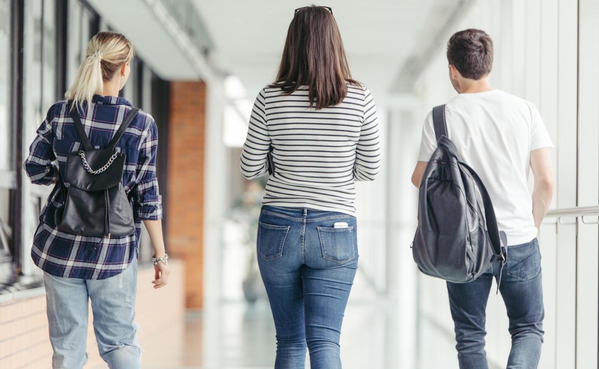 Estudiantes caminando por un pasillo.