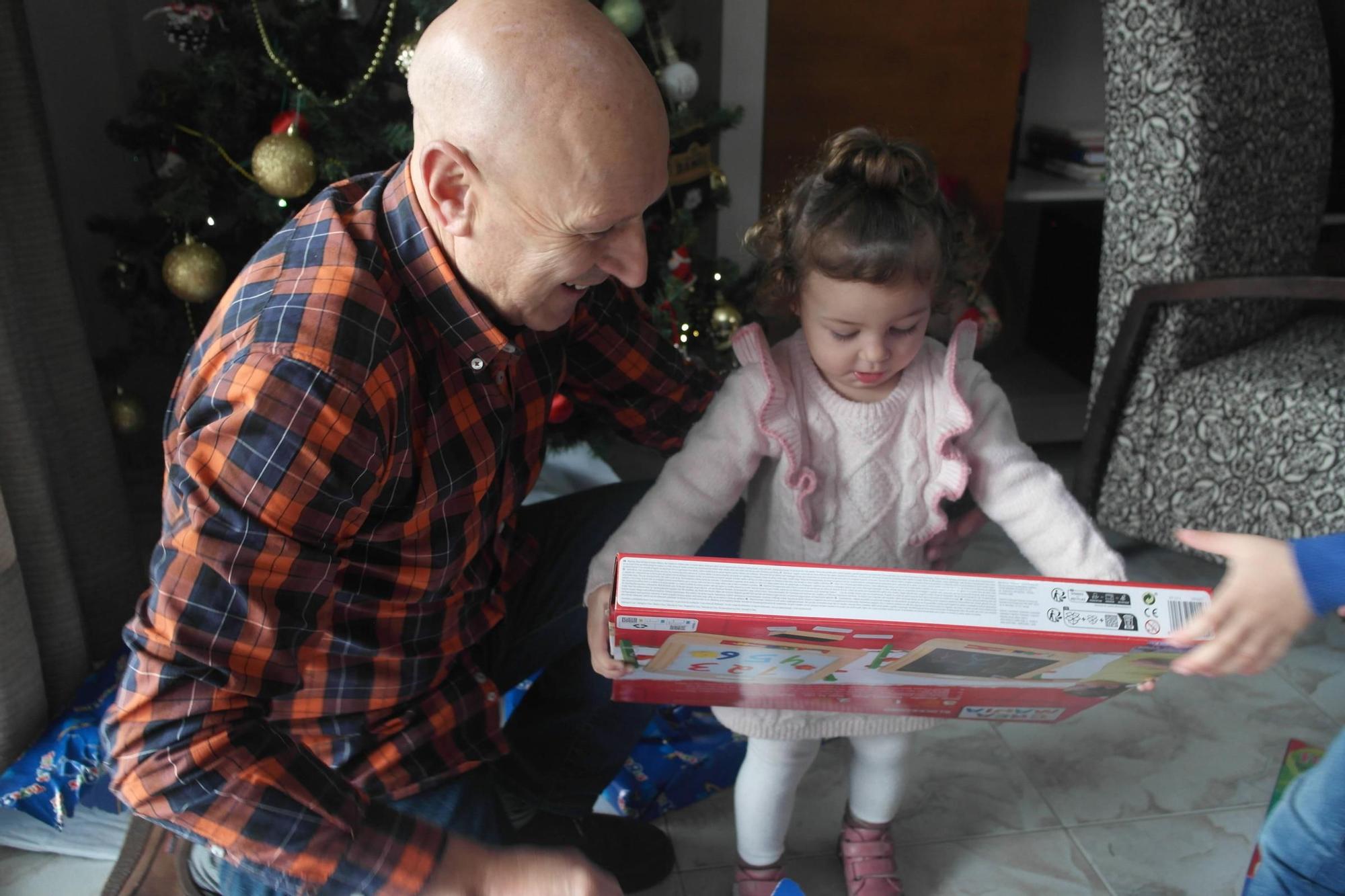 Daniela, de 22 meses, junto con su abuelo Juan José abriendo  sus regalos de Reyes Magos