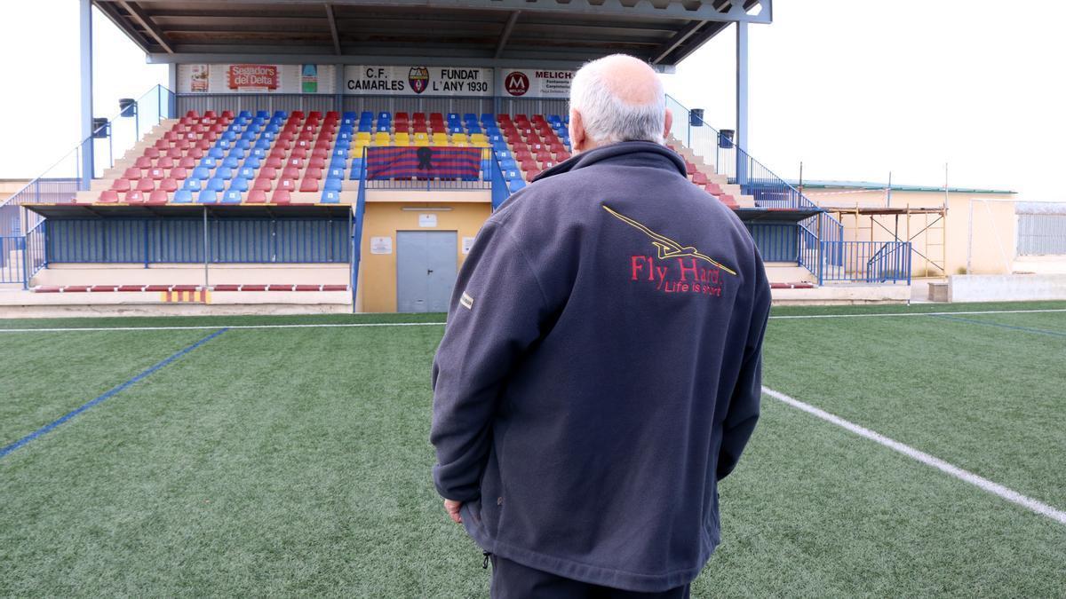 Un membre del club de futbol de Camarles mirant el crespó negre col·locat a les grades com a mostra de condol per la mort de tres joves del municipi, jugadors de l'entitat, en un accident de trànsit