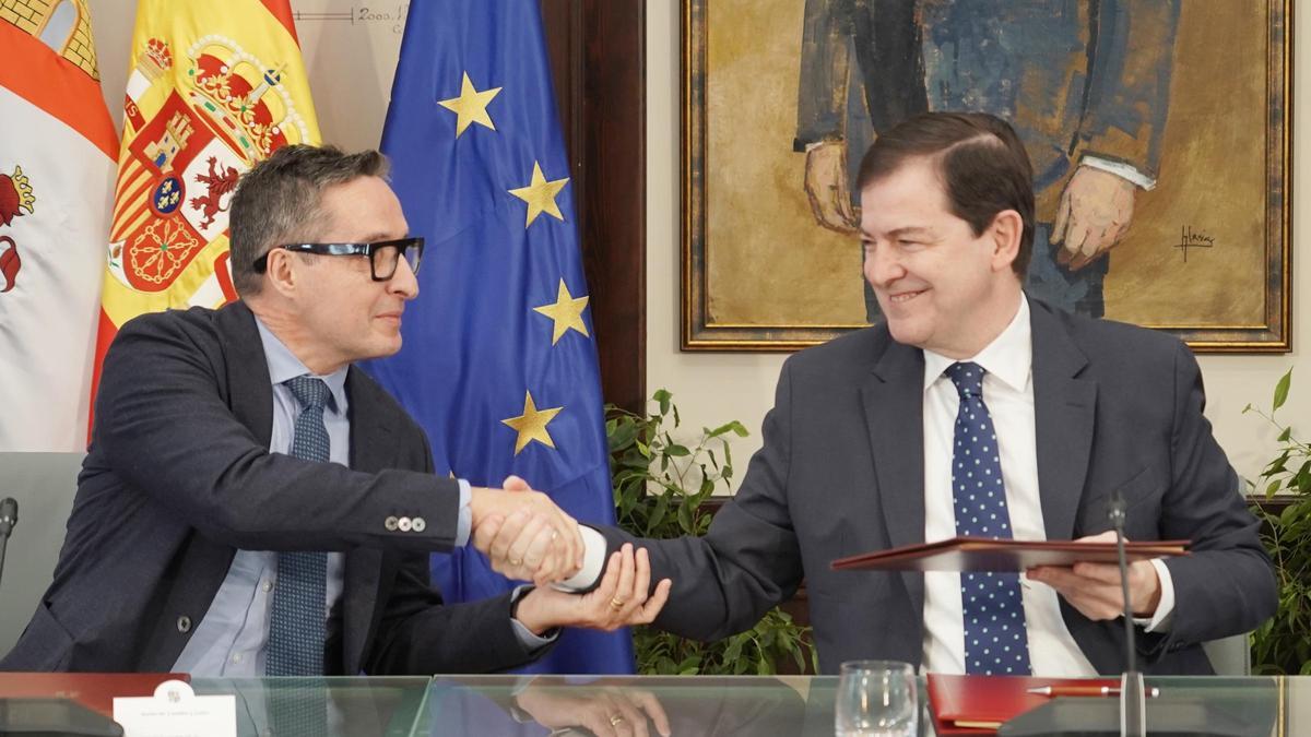 El rector de la USAL y el presidente de la Junta se dan la mano tras la firma del protocolo de colaboración.