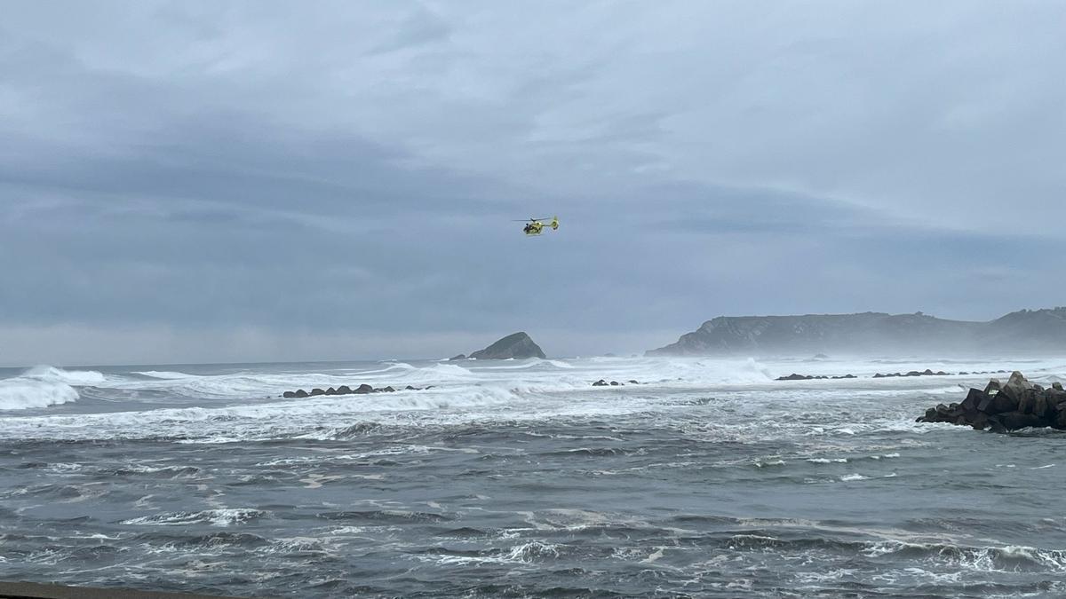 El helicóptero peina la zona de San Esteban donde cayó el hombre al mar, con mucho oleaje.