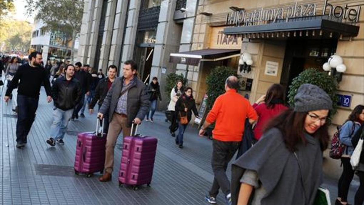 Viandantes cerca de un hotel en la plaza de Catalunya de Barcelona.