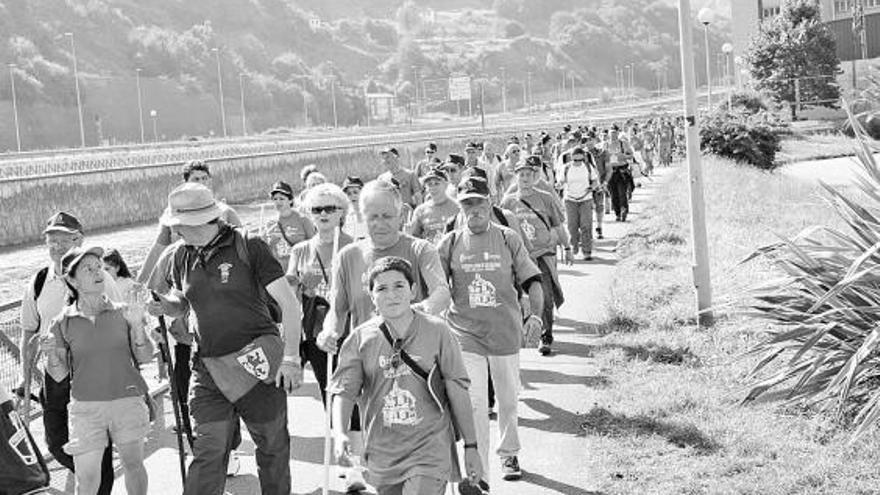 Los miembros de la Cofradía de la Vera Cruz de Cabanillas, caminando a la altura de Ujo.