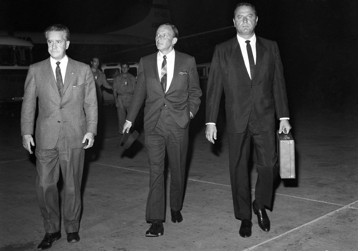 El actor estadounidense Frank Sinatra (c) llega al aeropuerto de Barajas, procedente de Málaga, para tomar un avión con destino a Nueva York