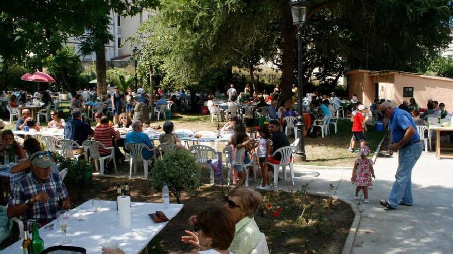 Las pobladas mesas en el parque candasín de Santarúa.