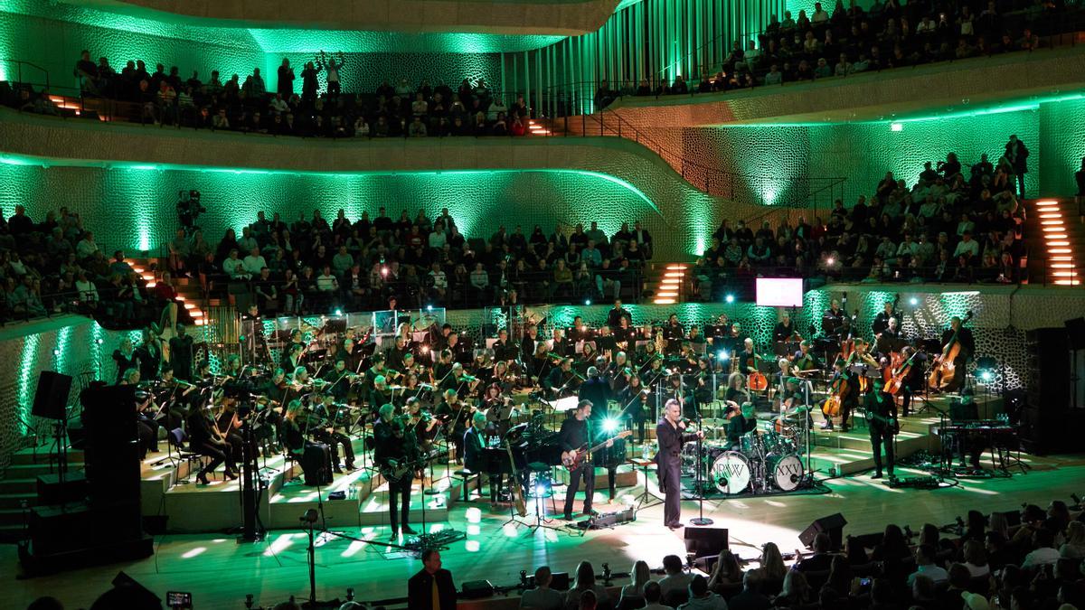 El cantante británico Robbie Williams y los músicos de la Nueva Orquesta Filarmónica de Fráncfort actúan en el escenario durante un concierto en directo en la Gran Sala de la Elbphilharmonie (Archivo).