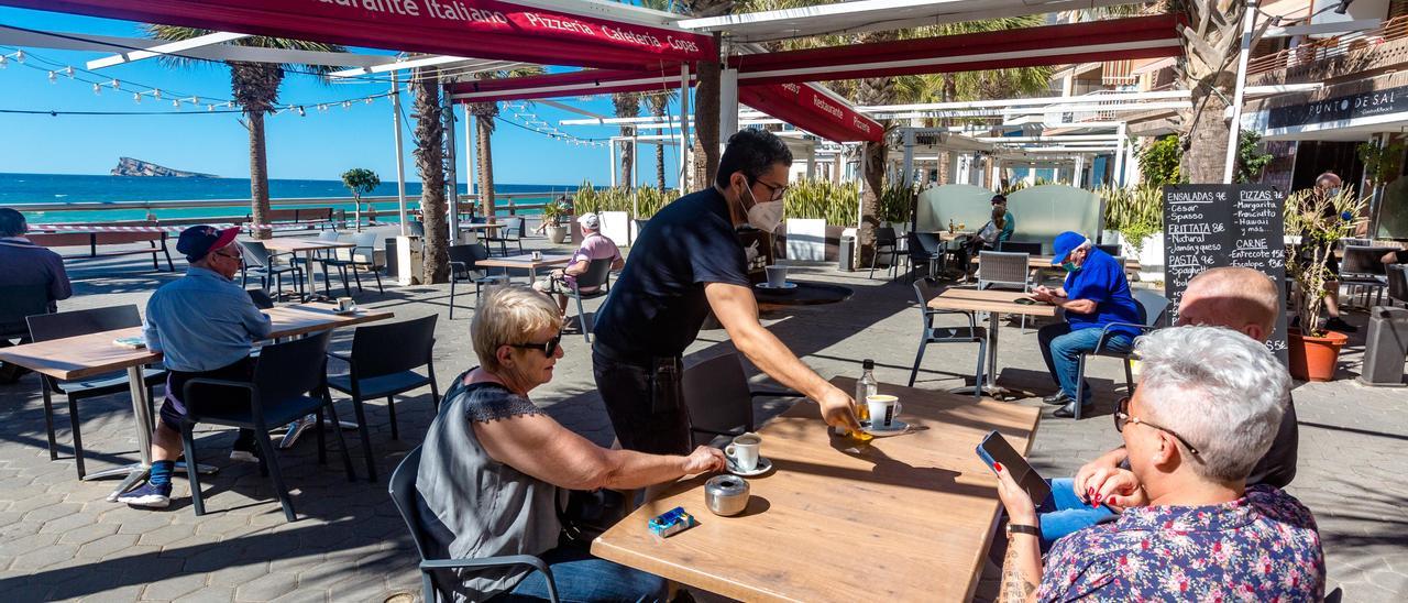 Un camero atienda una terraza en Benidorm