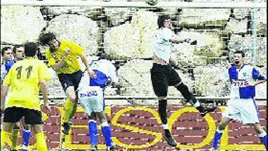 El portero arlequinado Adrián despeja la pelota en el partido ante el Cudillero.