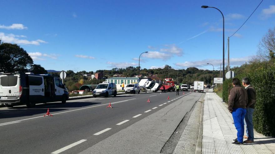 Instante en el que la grúa retira la furgoneta volcada de la vía.