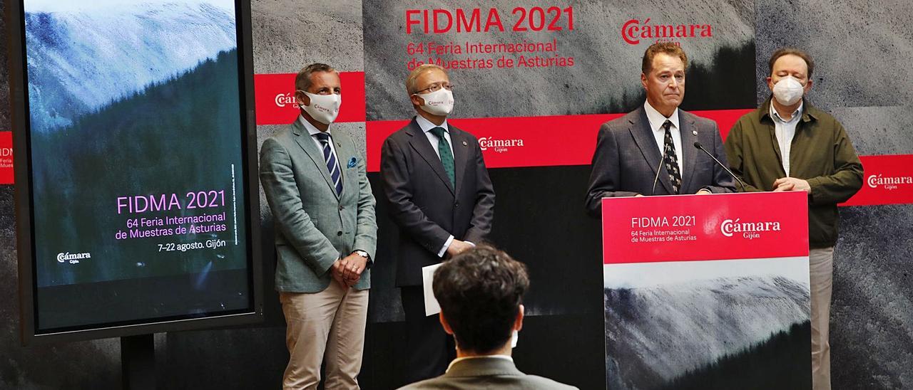 Por la izquierda, Pedro López Ferrer, Álvaro Alonso, Félix Baragaño y Avelino Mallo, autor de la pintura que sirve de base para el cartel de la 64.ª edición de FIDMA, expuesto a la izquierda de la imagen, durante la presentación del certamen, ayer. | Ángel González