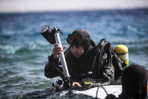 Un fotógrafo y una modelo trabajan bajo el agua en una sesión fotográfica de moda