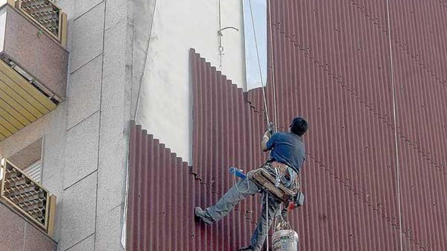 Uno de los operarios de la empresa realiza la impermeabilización de una fachada en Vilagarcía.