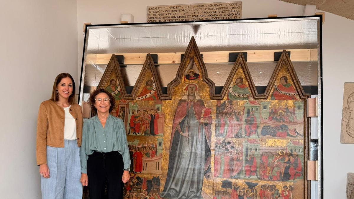 La vicepresidenta del Consell, Antònia Roca, y Maria Gràcia Salvà, directora del Museu de Mallorca, con el 'Retablo de Santa Quiteria'.