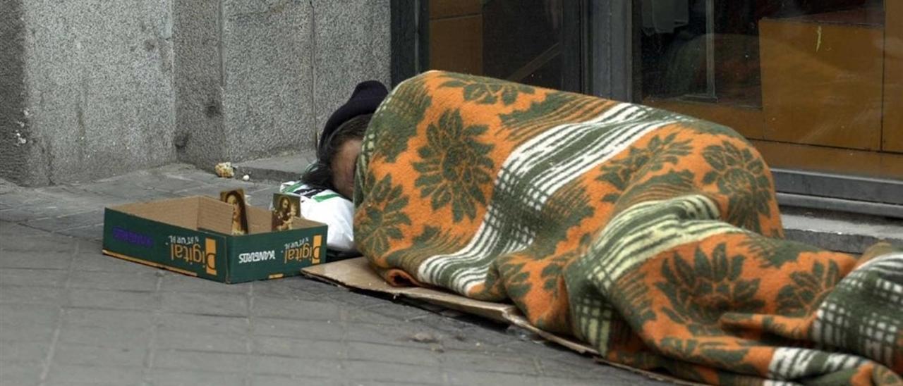 Una persona sin techo duerme en la calle