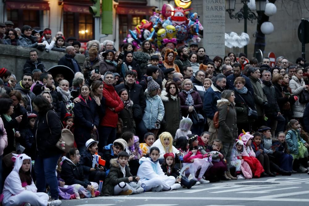 Veintitrés comparsas participan en el desfile por un abarrotado centro urbano.