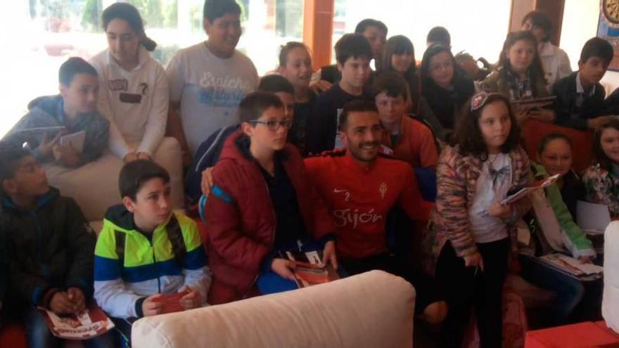 Arriba, Xavi Torres, posando con algunos alumnos tras la rueda de prensa. Sobre estas líneas, el joven invidente Alberto José Arroyo, ensayando su pregunta, ayer, en Mareo.