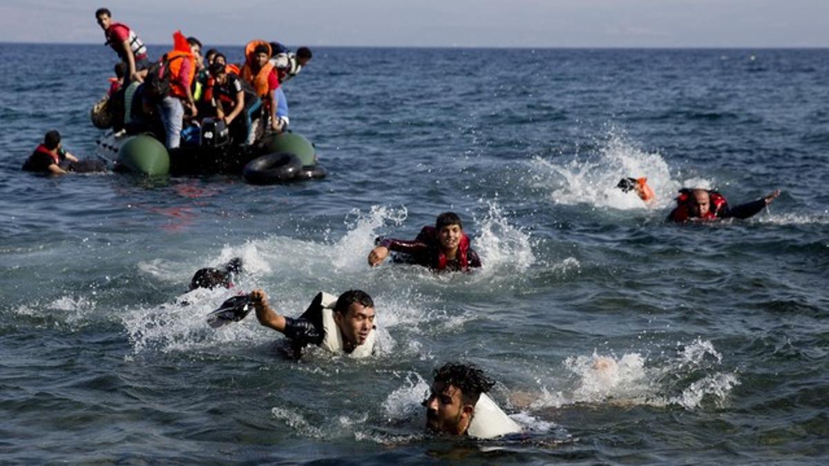 Inmigrantes tratan de subir a un bote, cerca de la isla griega de Lesbos, el pasado mes de septiembre.