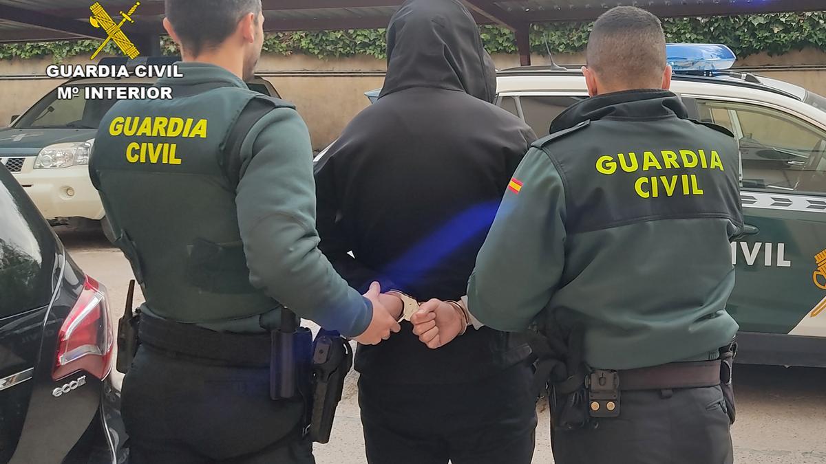 Dos agentes con uno de los arrestados en la operación 'Pacis'.