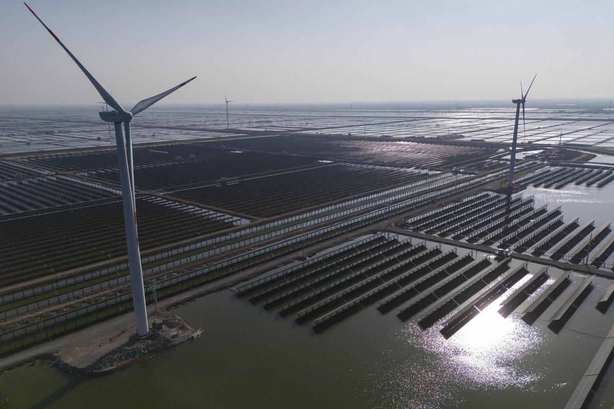 Molinos de viento en una megaplanta solar en la provincia de Shandong, en el este de China.
