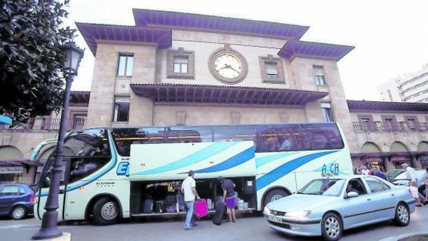 Dos pasajeros, introduciendo el equipaje en uno de los autobuses con los que se realizaron los transbordos.