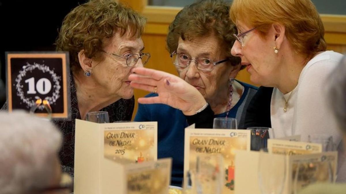 Tres asistentes a una de las comidas organizadas por Amics de la Gent Gran, en Barcelona.