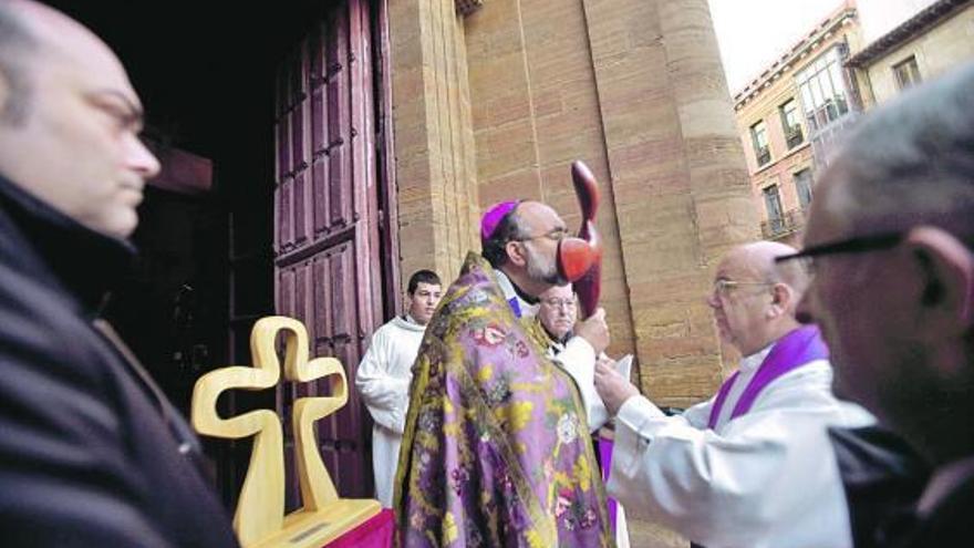 El arzobispo Jesús Sanz besa el Lignum Crucis sostenido por José Luis Alonso, en presencia de Agustín Iglesias Caunedo.