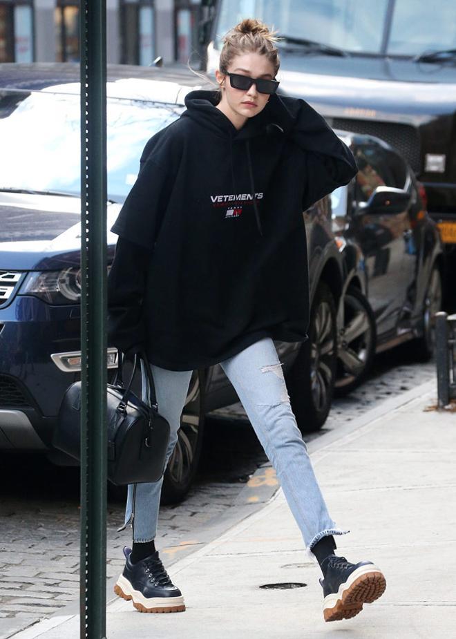 Gigi Hadid con look sport con sudadera negra de Vetements y deportivas