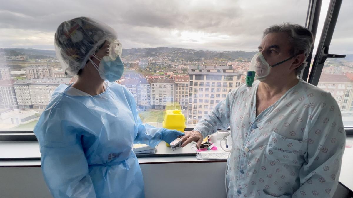 Celso Rodríguez con una sanitaria mirándose la tensión en la habitación. // FdV