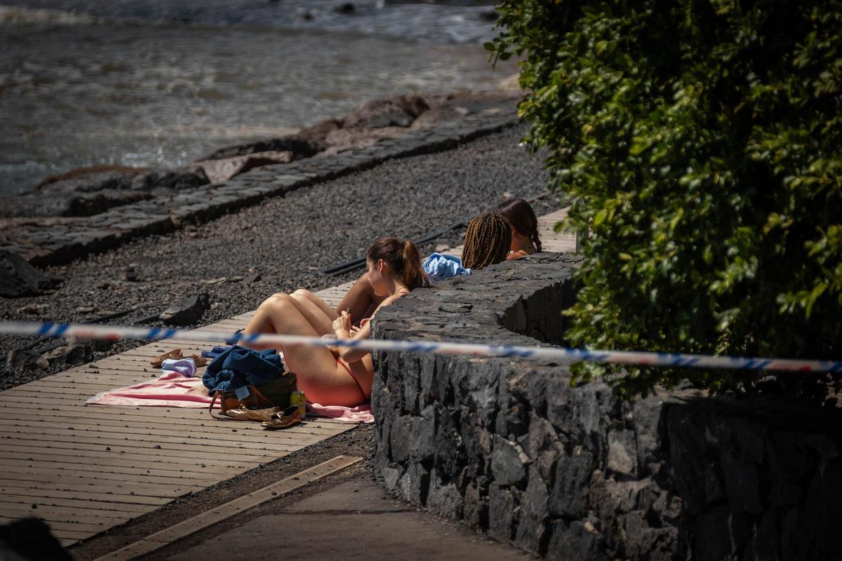 Bañistas se saltan la cinta de prohibido pasar en la costa de Radazul durante la alerta por la borrasca Therese.