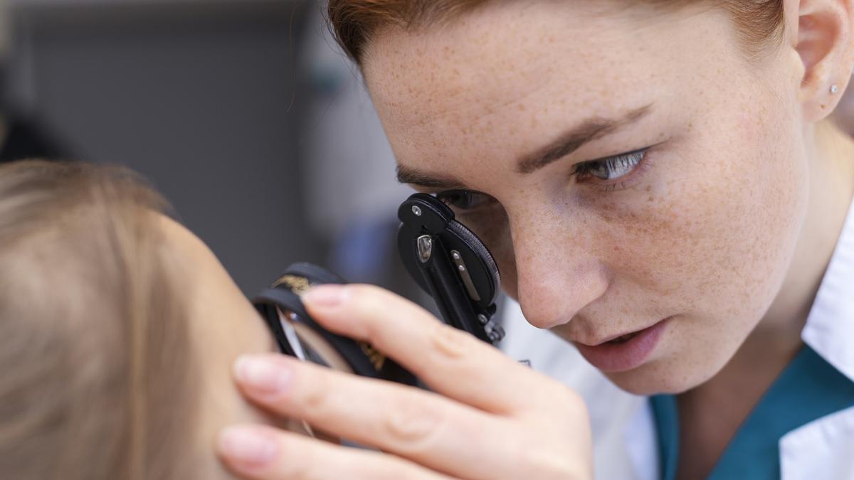 Una óptico-optometrista realiza una revisión ocular a una paciente.