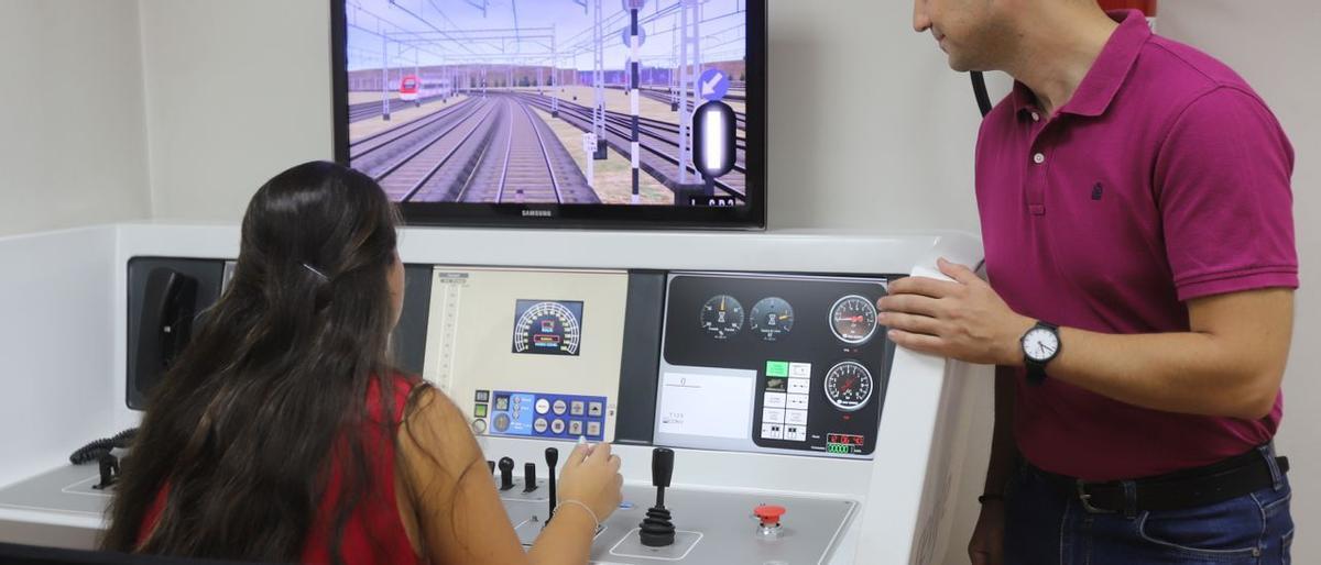 Dos de los becarios del Media Distancia y Cercanías de Renfe en Zaragoza, Nerea Molero y Alberto Peña, practican con el simulador ubicado en la estación del Portillo. / ANDREEA VORNICU