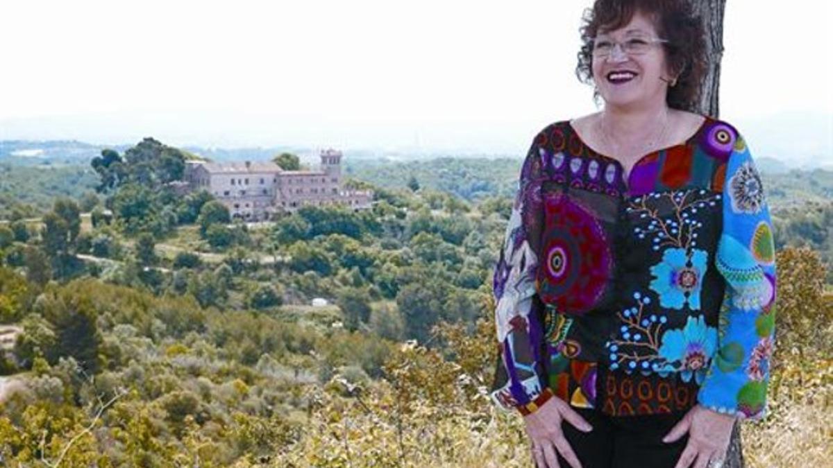 Neus Salarich, en la entrada de Ullastrell, con la masía de Can Palet dels Masovers al fondo.