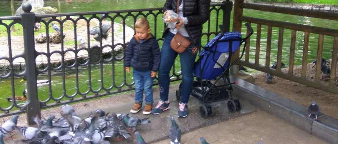 Ana Tcilo y su hijo Bernardo, ayer, dando de comer a las palomas junto al estanque del Campo San Francisco.