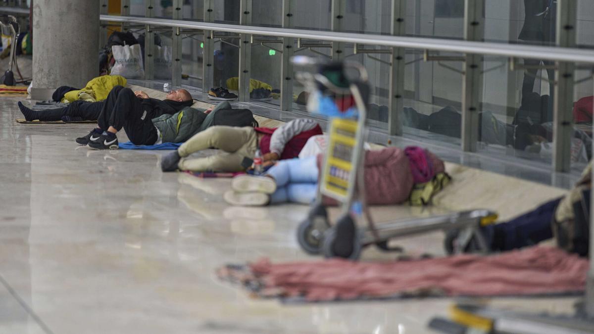 Personas durmiendo en la Terminal 4 del aeropuerto de Madrid-Barajas en la noche del 15 de mayo.