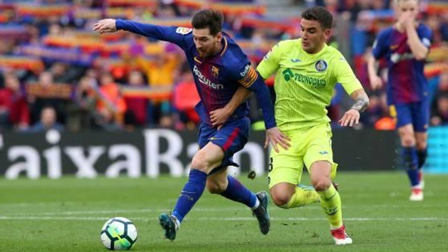 Leo Messi intenta escapolir-se de l&#039;escomesa d&#039;Arambarri (Getafe) en un partit al Camp Nou.