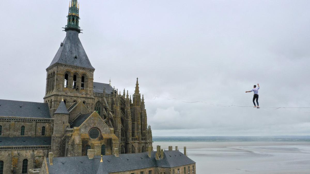 El funambulista francés Nathan Paulin, en acción: 2.200 metros de cable separaban el Mont Saint-Michel de la grúa que sostenía el cable por el otro lado.