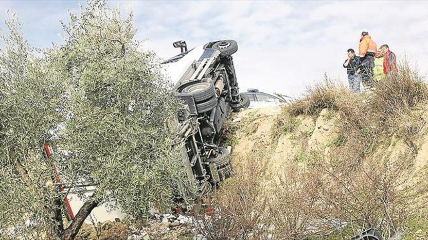 Un camión vuelca en un desnivel de terreno de un área de descanso de la n-331