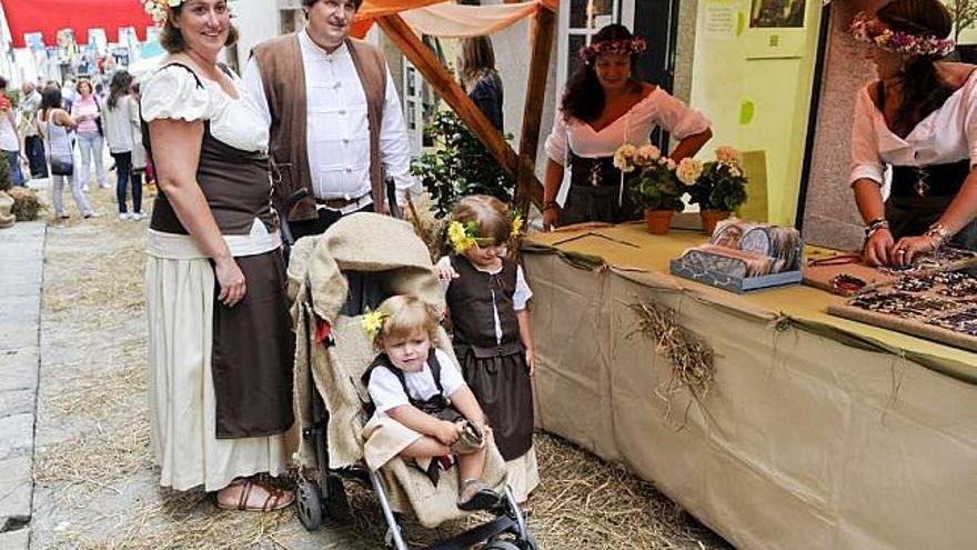 Una familia, ataviada con ropa medieval, pasea por el casco histórico de Pontedeume. / fran martínez