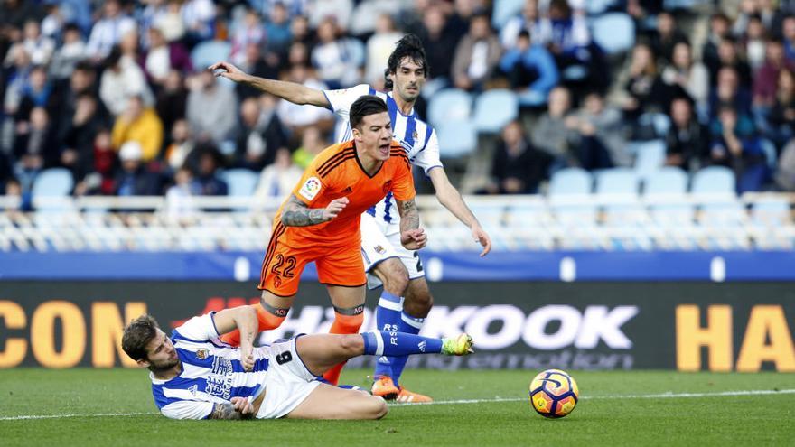El defensa de la Real Sociedad Iñigo Martínez (i) realiza un penalti contra el delantero Santi Mina